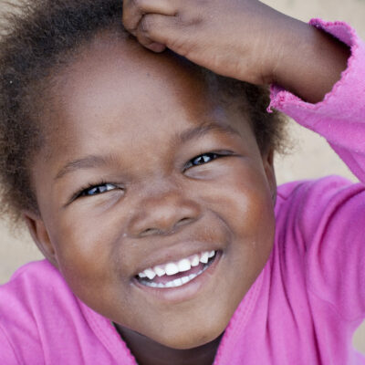 Young African girl smiling for the camera.